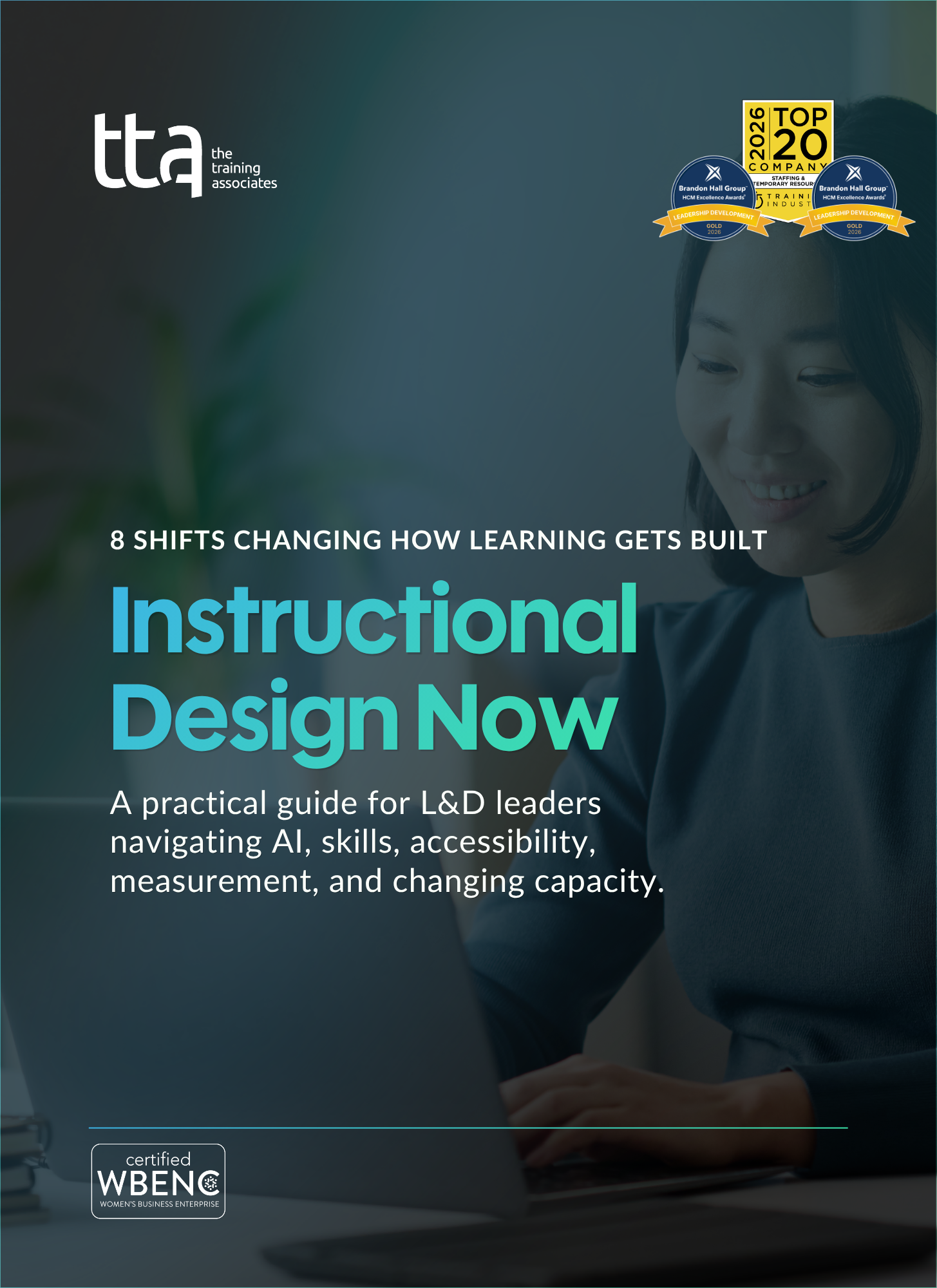 Cover of TTA's Instructional Design Now eBook showing a woman smiling at her laptop, with the title, subtitle, and award badges.